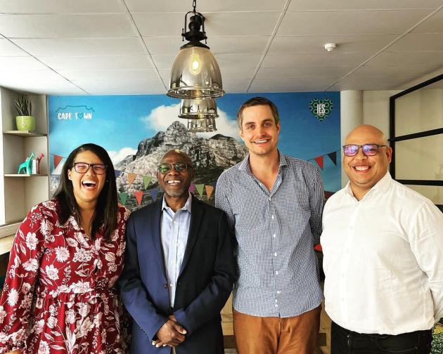 four ies abroad staff members in business casual attire laugh and smile in the cape town center