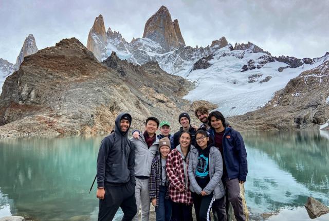 a group of students pose for a photo in front of mountains and a lake in Patagonia
