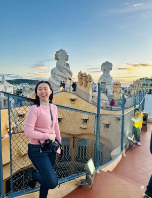 student standing on steps in front of colorful fence and textured buildings