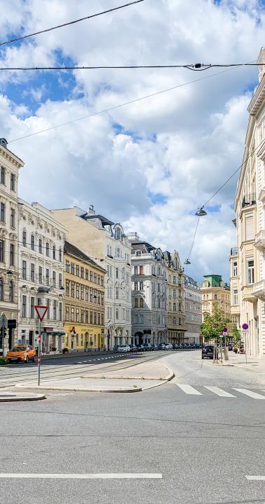 An empty street in Vienna, Austria lined with white buildings.