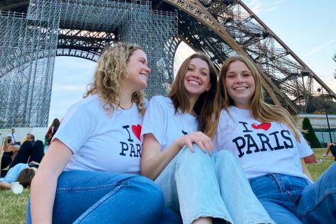 three female students having fun at the Eiffel Tower